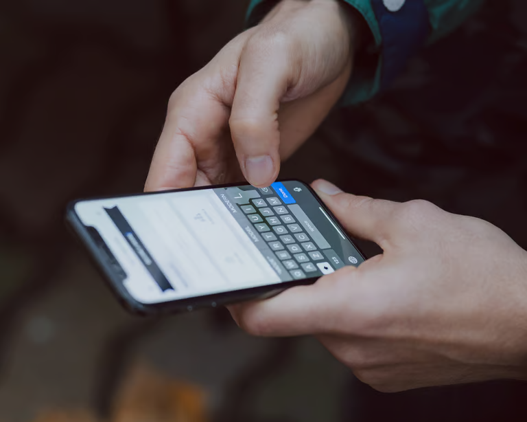 Hände tippen eine Nachricht auf dem Smartphone